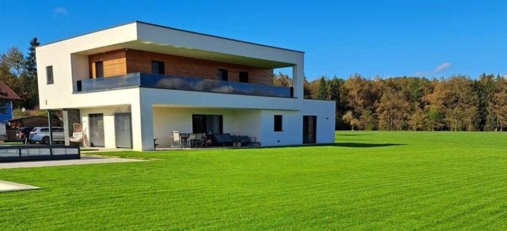Fertiger, sattgrüner Rasen vor einem modernen Einfamilienhaus